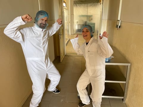 Two colleagues in protective suits striking a pose