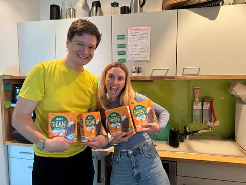 Two colleagues proudly holding up product packs